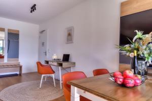 a living room with a table and orange chairs at Ferienwohnung Haubentaucher 25 im Wreecher Idyll Rügen by ruyastay in Putbus