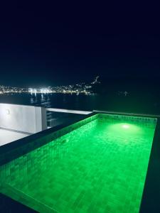 a swimming pool at night with a view of the city at Casa Ibiza - Pontal do Atalaia - Arraial do Cabo in Arraial do Cabo