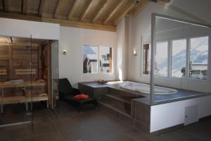 Das Bad ist mit einer Badewanne und einer Glasdusche ausgestattet. in der Unterkunft Apartments Residenz Iris in Leukerbad