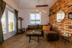 a living room with a couch and a brick wall at Gora Apartments 3 in Vrdnik