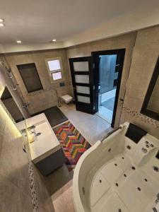 a large bathroom with a tub and a sink at Standalone Villa in New Cairo, Private swimming pool and modern furniture in Cairo