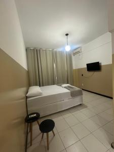 a bedroom with a bed and a tv in it at Pousada Aconchegante in Jequié +44 photos