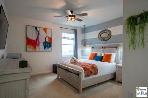 a bedroom with a bed and a ceiling fan at Deluxe themed private ROOMS - Ensuite Bath & Pool Access by Casa Da Jura in Kissimmee