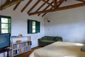 a bedroom with a bed and a couch and a tv at Alameda Country House in Tenjo