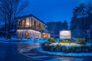 a building with a sign in front of it in the snow at JADE D Plus and E Plus Hakuba in Hakuba +72 photos