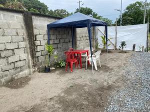 a table and chairs under a blue tent at El Rincón de Charito in Tumaco