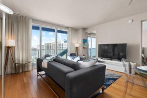 un soggiorno con un divano e una grande finestra di 2BR W Resort, Birds eye view of it all, Professionally Designed a Fort Lauderdale
