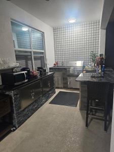 a large kitchen with a counter and a table at Deluxe themed private ROOMS - Ensuite Bath & Pool Access by Casa Da Jura in Kissimmee