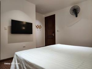 a bedroom with a white bed and a flat screen tv at SUN HOTEL & APARTMENT in Bắc Ninh