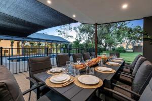 a table with plates and glasses on a patio at Palamcotta Lodge in Moama +24 photos