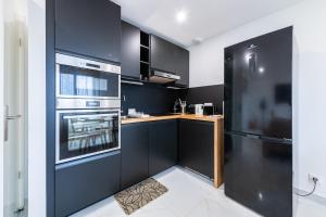 cocina con armarios negros y fogones en Lovely appartement proche Disney, en Vaires-sur-Marne