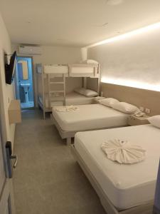 a room with three bunk beds and a hallway at Hotel San Sebastian Real in Cartagena de Indias