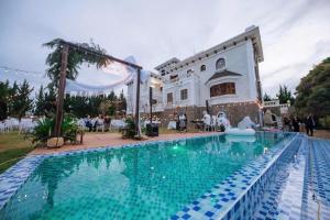 a swimming pool in front of a building at Biệt Thự Đà Lạt Nghỉ Dưỡng Gia Đình in Trai Mat