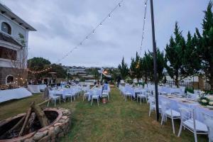 an outdoor wedding with white tables and chairs at Biệt Thự Đà Lạt Nghỉ Dưỡng Gia Đình in Trai Mat