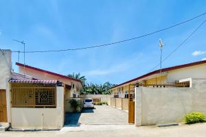 TebingtinggiにあるRedDoorz at Shine Guest House Tebing Tinggiの門と私道の並ぶ建物