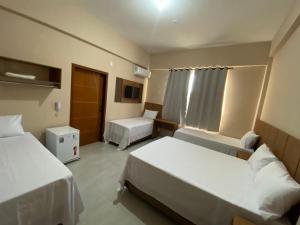 a hotel room with two beds and a window at Hotel Primavera Palace in Salinas