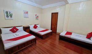 a room with two beds with red and white sheets at Roccksar Pension House in Puerto Princesa City +11 photos