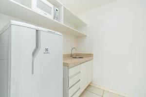 a white kitchen with a refrigerator and a sink at Vision Hotel em Brasília 60300 in Brasilia