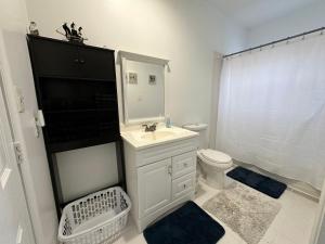 a white bathroom with a sink and a toilet at New Oasis by DC in Hyattsville