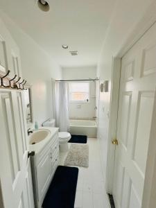 a white bathroom with a sink and a toilet at New Oasis by DC in Hyattsville