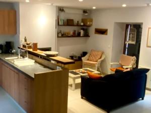 a kitchen and living room with a counter and chairs at Charmante maison familiale à Groix, 3 chambres - FR-1-813-5 in Groix