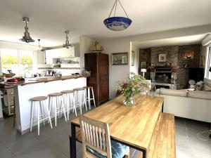 a kitchen and living room with a wooden table and chairs at Maison familiale proche plage Groix, jardin et garage - FR-1-813-6 in Groix