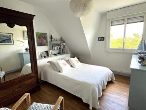 a bedroom with a white bed and a mirror at Maison familiale proche plage Groix, jardin et garage - FR-1-813-6 in Groix