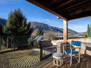 a deck with a desk and two chairs on it at Appartement moderne 4 pers, proche SkyVall, parking gratuit - FR-1-695-63 in Loudenvielle