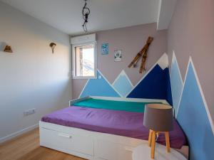 a bedroom with a blue and purple bed with a window at Appartement moderne 4 pers, proche SkyVall, parking gratuit - FR-1-695-63 in Loudenvielle