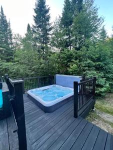 a hot tub sitting on a wooden deck at Luxury with hot tub 300mbps Wifi Games & more ! in Saint Adolphe D'Howard