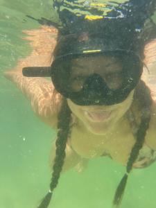 a person swimming in the water with a hat on at Bee Lucky Homestay in Hai Phong