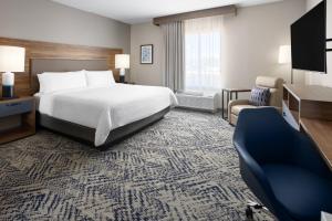 a hotel room with a bed and a chair at Candlewood Suites Chattanooga - East Ridge by IHG in Chattanooga +37 photos