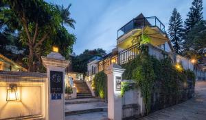 a house with a staircase and an umbrella at Gulangyu Sunlit Rock Garden Resort in Xiamen