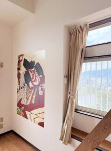 Habitación con ventana y pintura de un gato en 高平ハウス Room106, en Nagasaki 21 fotos más