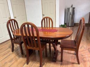 a wooden dining room table with four chairs and a refrigerator at XIMEL House in Flores