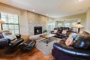 Una sala de estar con muebles de cuero y chimenea. en The Rose cabin, en Gatlinburg