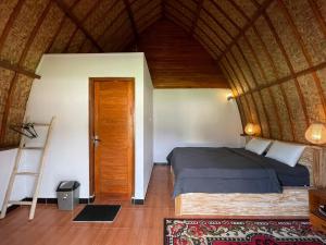 a bedroom with a bed and a wooden ceiling at Volcano Cabins in Kubupenlokan