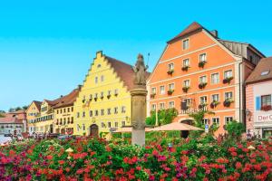 een groep gebouwen en bloemen in een stad bij WAGNERS Hotel Greifen-Post in Feuchtwangen