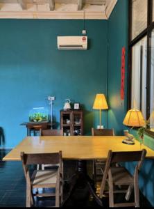 ein Esszimmer mit einem großen Holztisch und Stühlen in der Unterkunft CHCH by LEJU in Malakka