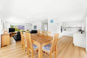 a kitchen and dining room with a wooden table and chairs at 19 Mort Avenue - Dalmeny Lakeside in Dalmeny