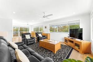 a living room with a couch and a flat screen tv at 19 Mort Avenue - Dalmeny Lakeside in Dalmeny
