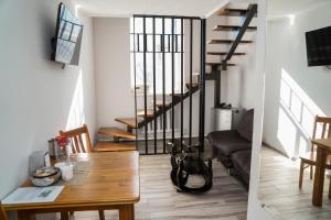 a living room with a dining room table and a staircase at Гостевой дом Северный Дворик in Kostanay