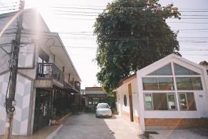 a car parked on a street next to a building at Sleepy House Chiang Rai in Chiang Rai