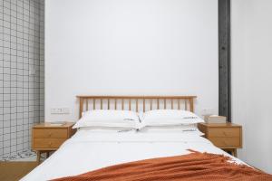 a bedroom with a white bed with two night stands at Gulangyu Sunlit Rock Garden Resort in Xiamen