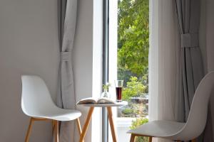a window with two white chairs and a table with a wine glass at Gulangyu Sunlit Rock Garden Resort in Xiamen