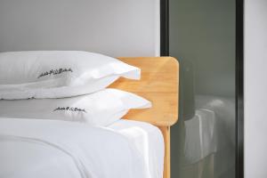 a pile of pillows sitting on top of a bed at Gulangyu Sunlit Rock Garden Resort in Xiamen