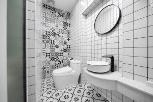 a bathroom with a toilet and a sink and a mirror at Gulangyu Sunlit Rock Garden Resort in Xiamen