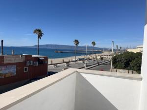 a view of a beach with palm trees and the ocean at Stella Marina Home Holidays in Gioia Tauro