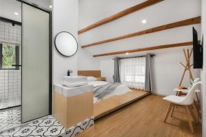 a bedroom with a bed and a sink and a mirror at Gulangyu Sunlit Rock Garden Resort in Xiamen