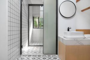 a bathroom with a shower and a sink and a mirror at Gulangyu Sunlit Rock Garden Resort in Xiamen